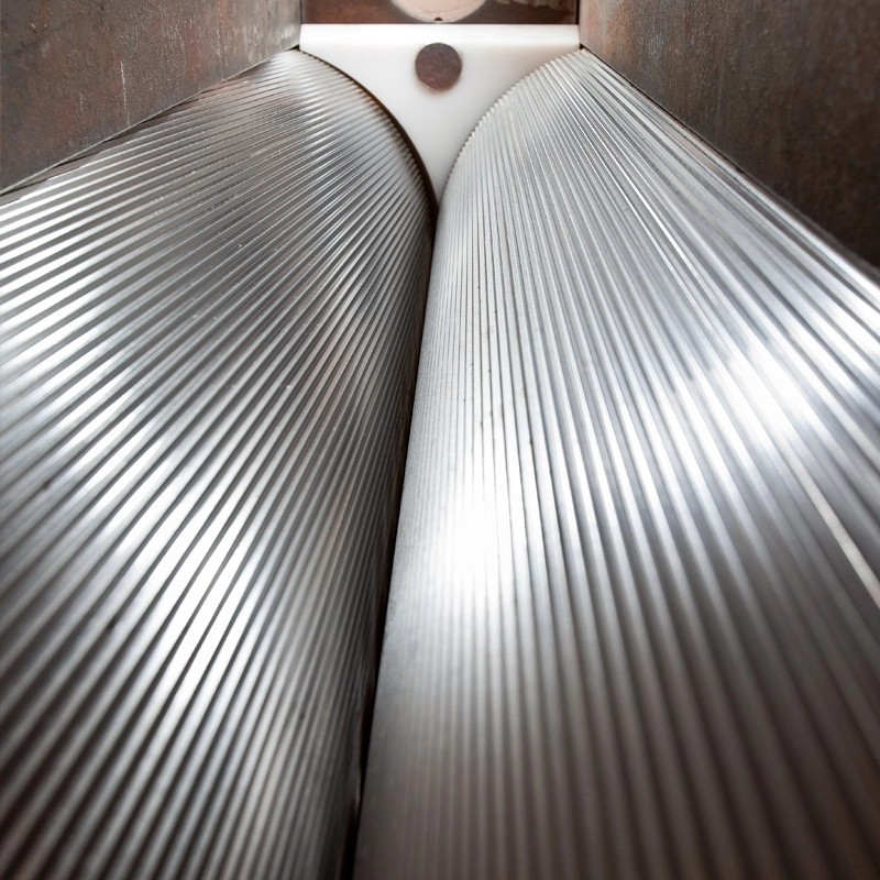 Close-up view of precision corrugated rolls inside an Gundlach Crushers® NANOSIZ-R® roll mill designed for controlled fine grinding and uniform particle reduction.