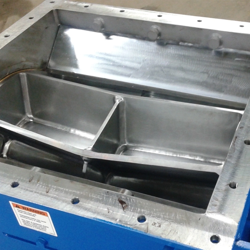 Close-up inlet view of a Jeffrey Rader® EDK Rotary Feeder/Delumper showing the internal rotor assembly and stainless steel feed chamber for controlled material handling.