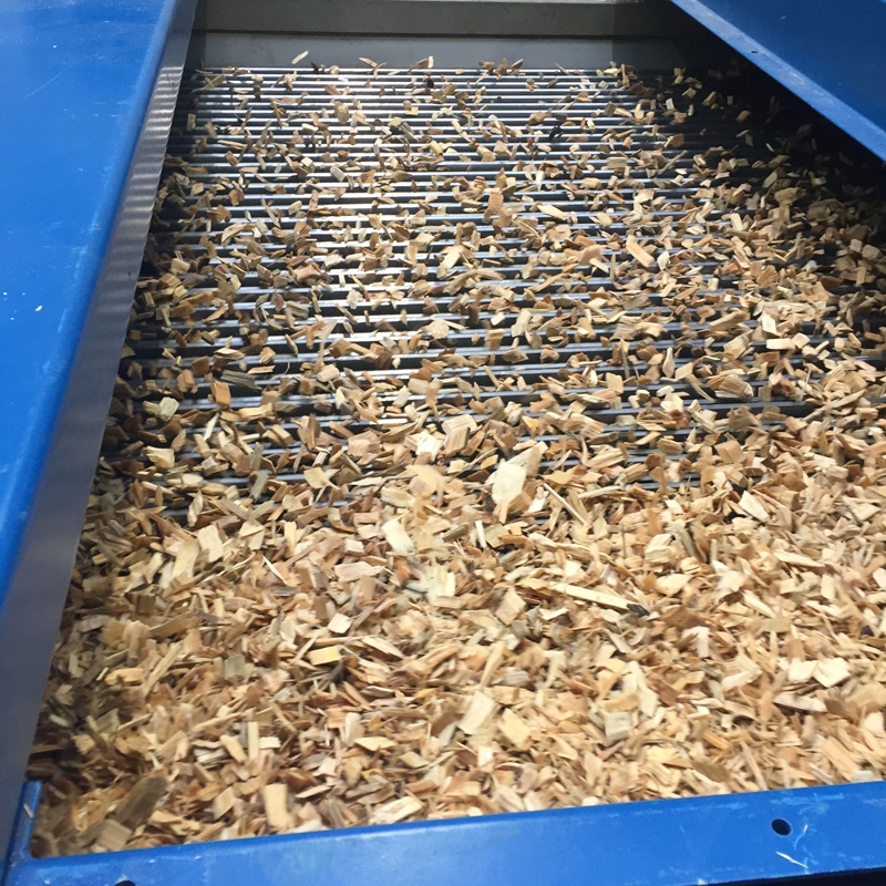 Close-up view of wood chips moving across the screening bars of a Jeffrey Rader® DynaGage™ Bar Screen during chip thickness classification.