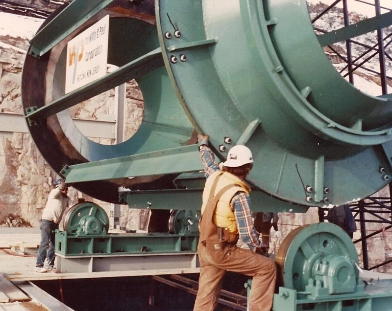 Workers assembling a large Pennsylvania Crusher Bradford Breaker drum at a mining site, showing the machine’s heavy-duty wheel-mounted support structure and rotating cylinder design.