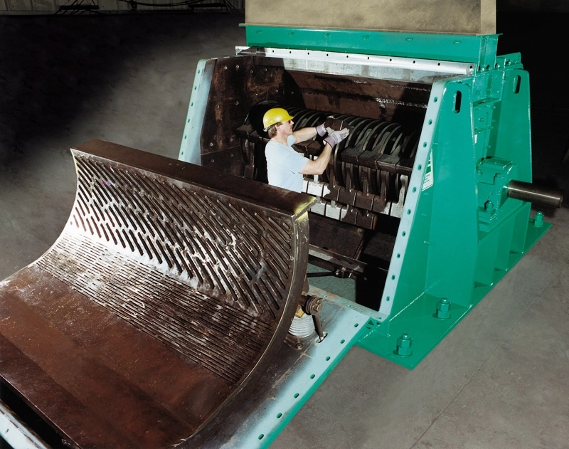 Technician performing maintenance inside an open Pennsylvania Crusher reversible impactor with access to internal components